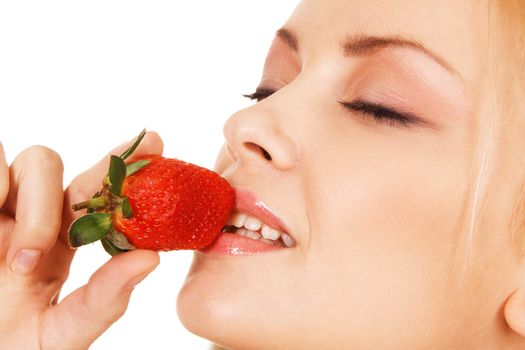 Beautiful girl tasting a strawberry, face portrait