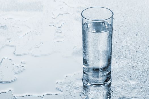 Glass of water on blue background, studio photo