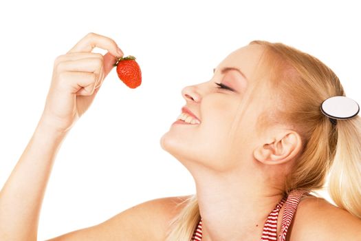 Beautiful girl tasting a strawberry, face portrait