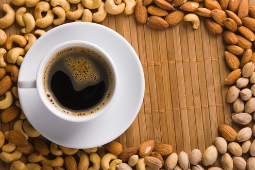 Delicious coffee with nuts on the background