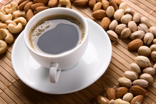 Delicious coffee with nuts on the background 