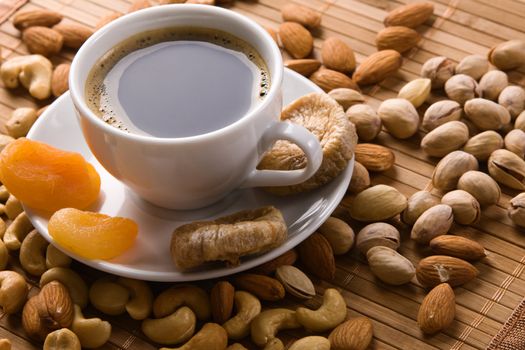 Coffee with nuts, fig and dried apricots still life