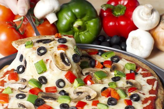 Horizontal image of supreme pizza with ingredients on the background