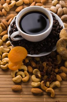 Coffee with nuts, fig and dried apricots still life