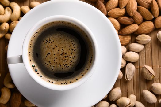 Delicious coffee with nuts on the background