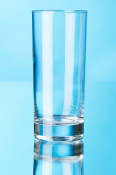 Empty glass on blue background, studio photo