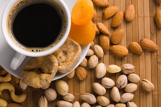 Coffee with nuts, fig and dried apricots still life