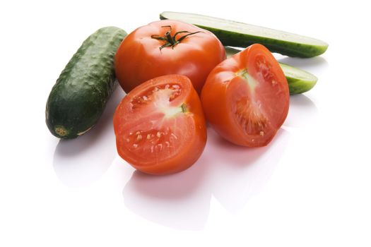 Tomatoes and cucumbers on white background