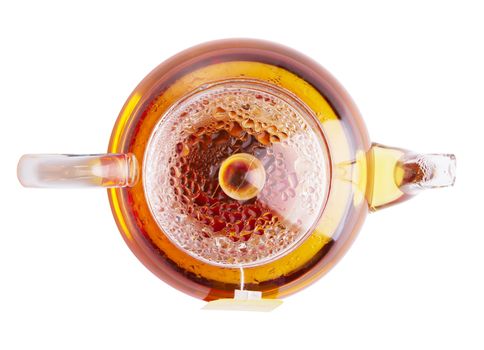 Glass teapot of hot black tea on white background