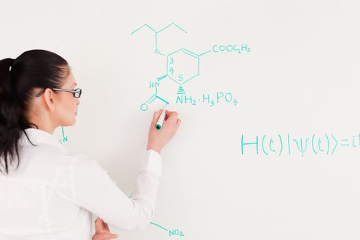 Scientist writing a formula on a white board