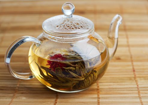 Glass teapot with hot white tea 