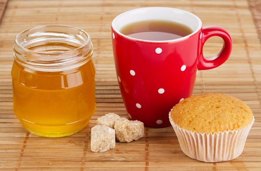 Cup of sweet tea with cakes and honey