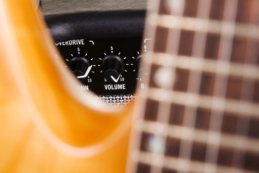 Electric guitar with amplifier, extreme closeup on volume knob