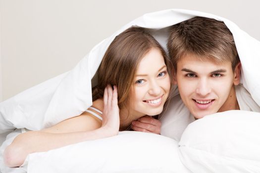 Young beautiful couple in bed