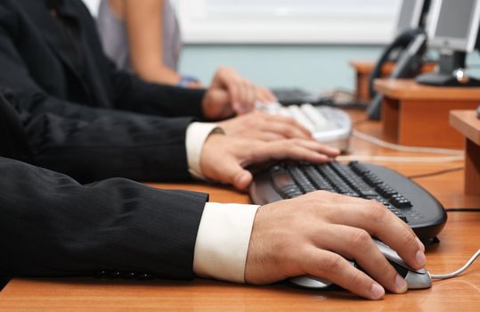 Closeup view of businessman's hands on a mouse and keyboard