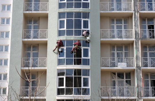 Three steeplejacks working on a newly built house