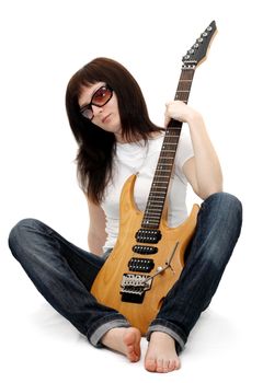 Pretty young girl sitting and holding an electric guitar