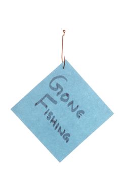 Isolated image of a blue paper with &quot;Gone Fishing&quot; text caught in a hook against white background