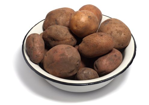 Bowl of raw organic potatoes isolated on white background