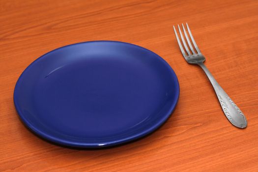 Blue empty plate with a fork