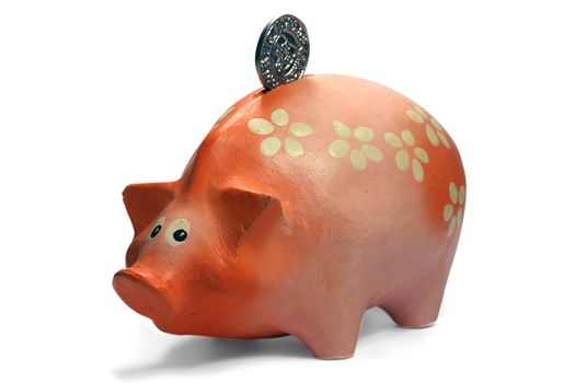 Ruddy piggy bank made of clay isolated on white background