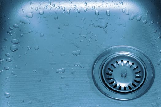 Wet kitchen sink close-up in blue tones