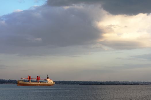 Red cargo vessel in a bay