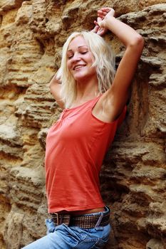 Beautiful girl posing on a stone wall background