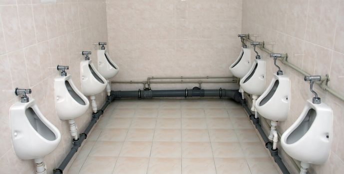 Two rows of urinals in a toilet