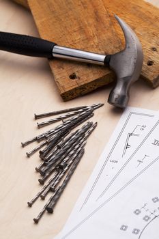 A desk with nails, hammers and blue prints