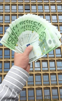 Businessman holding stack banknotes in EUR 100
