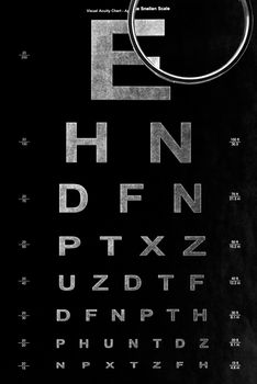 Close-up shot of black eye test chart and magnifying glass.