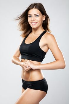 Young fit woman in sports outfit, studio photo