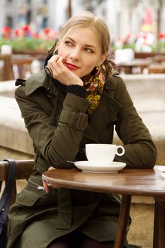 Beautiful woman drinking coffee in outdoor cafe