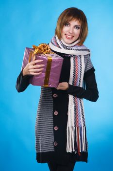 Portrait of lovely girl with Xmas gift over blue background