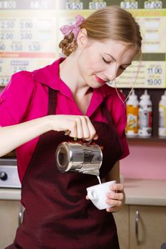 Friendly waitress making coffee at coffee machine