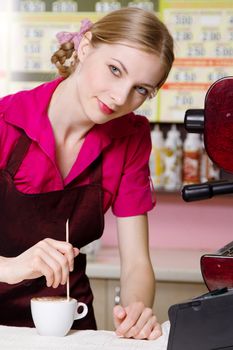 Friendly waitress making coffee at coffee machine