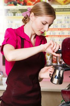 Friendly waitress making coffee at coffee machine