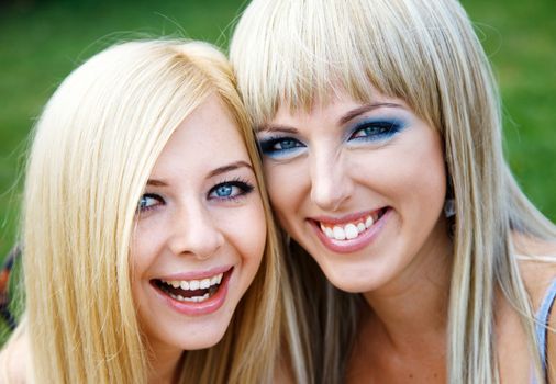 Two young pretty girl friends in a park