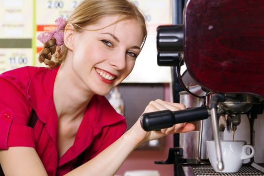 Friendly waitress making coffee at coffee machine