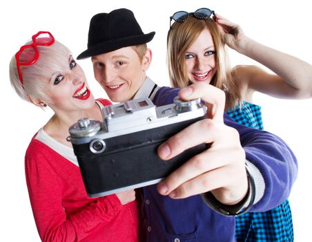Three joyful teenage friends with old photo camera