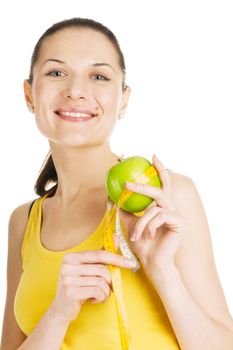 Beautiful young girl in sports outfit holding an apple, white background