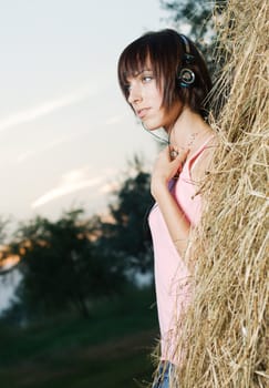 Lovely girl in headphones listening a music outdoors