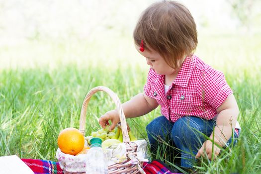 Cute child on a picnic, eating a big fresh apple