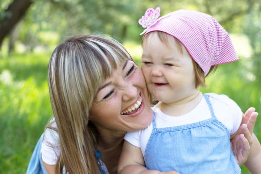 Cheerful mother with her daughter outdoor portrait