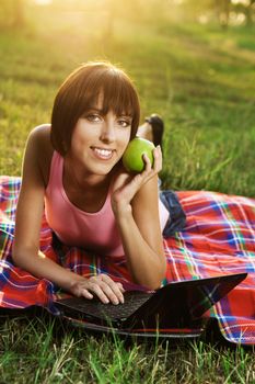 Lovely girl having a rest with laptop on picnic