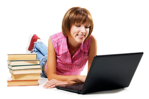 Cheerful girl with laptop and stack of books, white background 