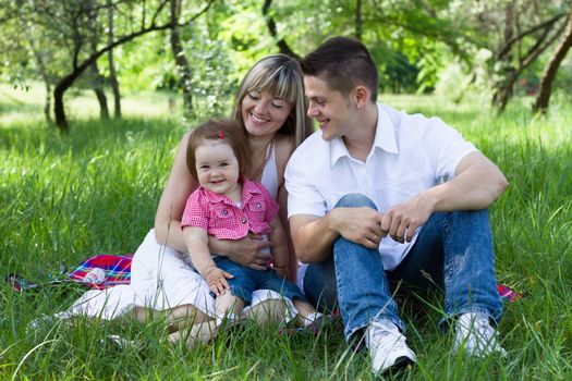 Young beautiful family of three on a picnic