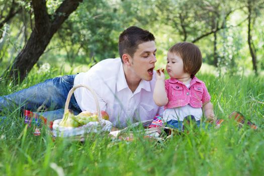 Young beautiful family of three on a picnic