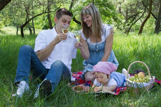 Young beautiful family of three on a picnic